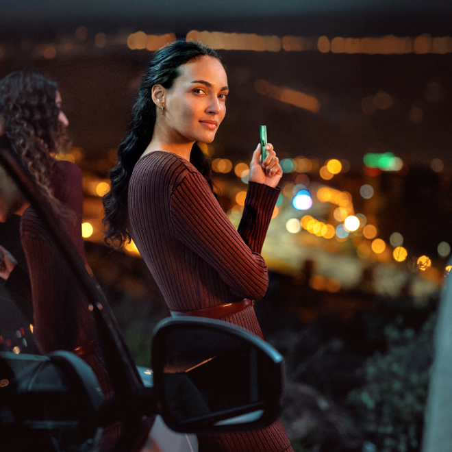 2 femei zambesc folosind dispozitivul IQOS